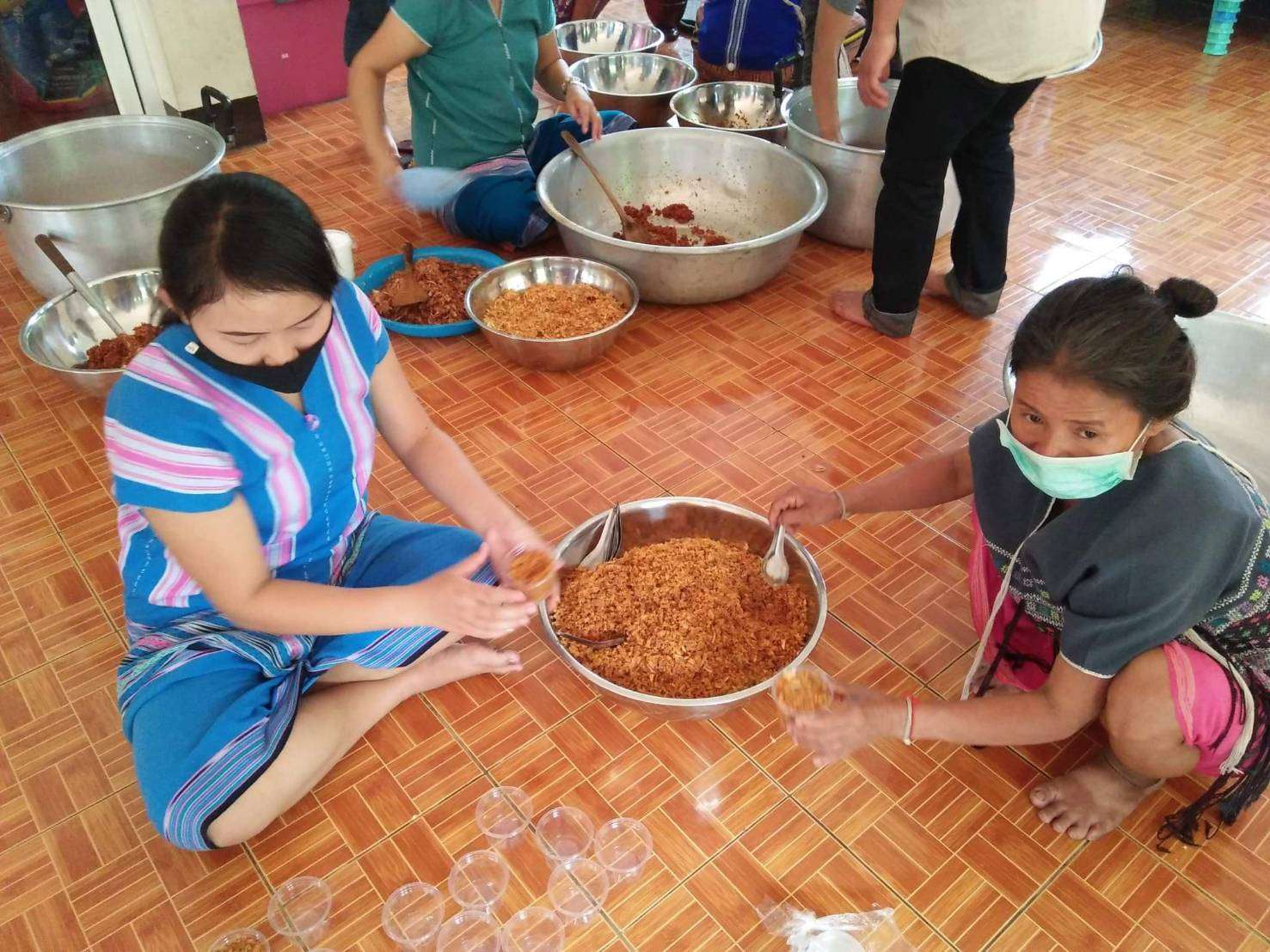 Youth and parents make galangal chili paste and salted fish.