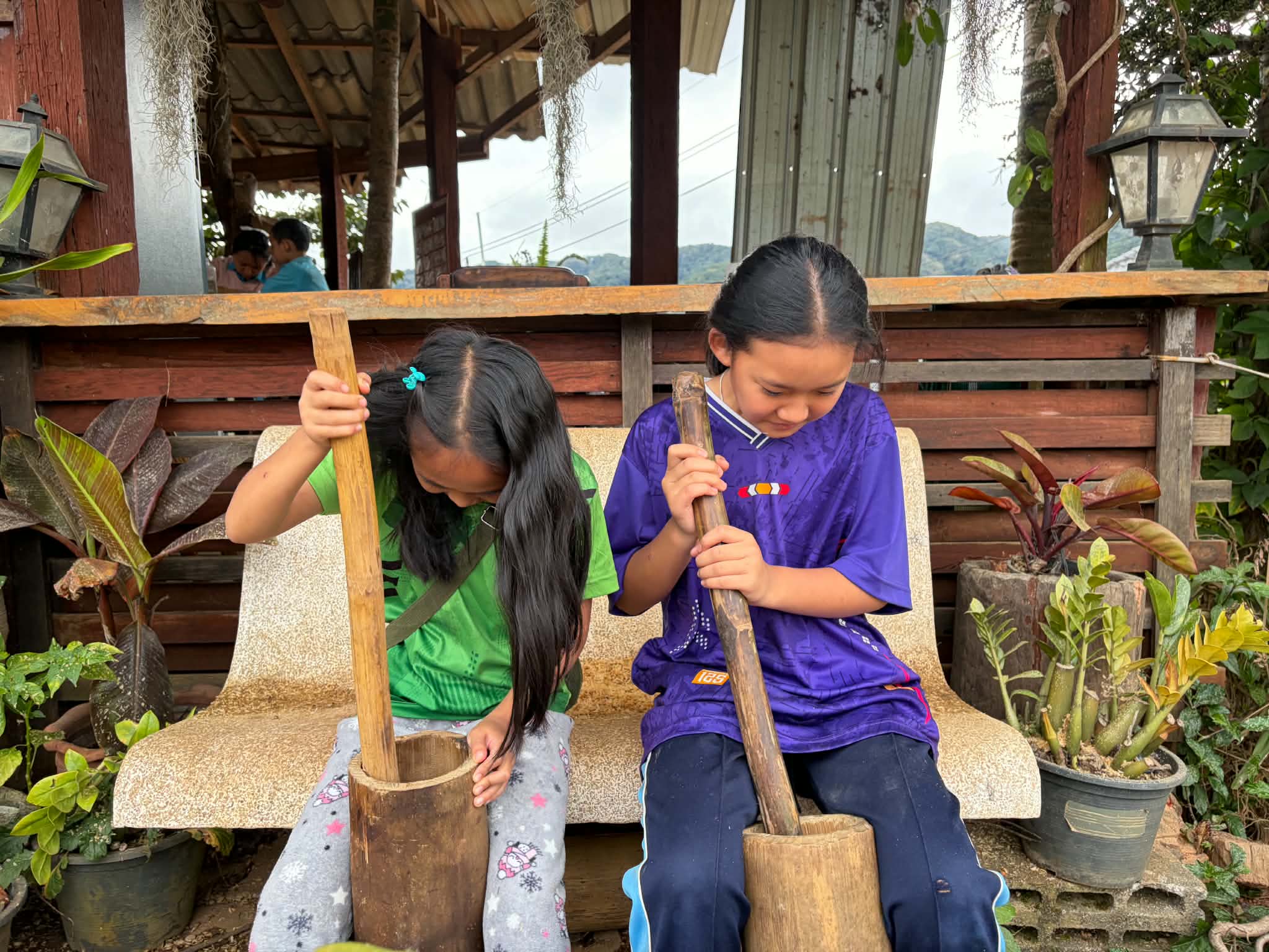 The children learned the process of grinding coffee beans in the husk to extract the coffee pigment.