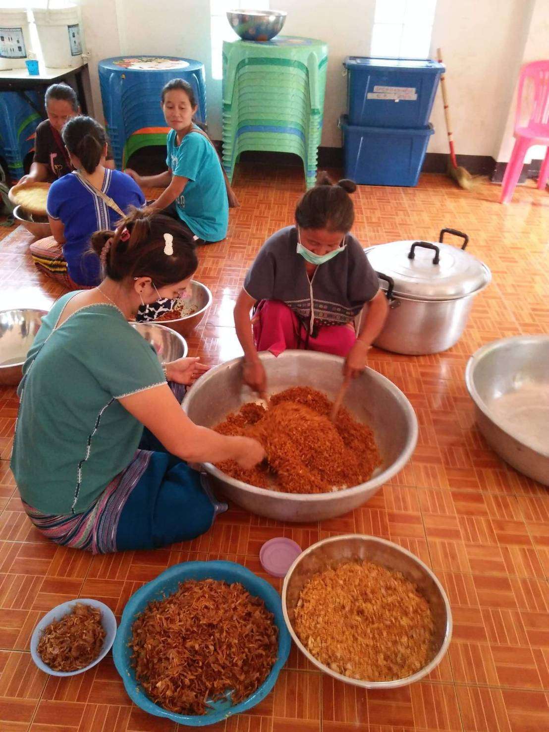 Youth and parents make galangal chili paste and salted fish.