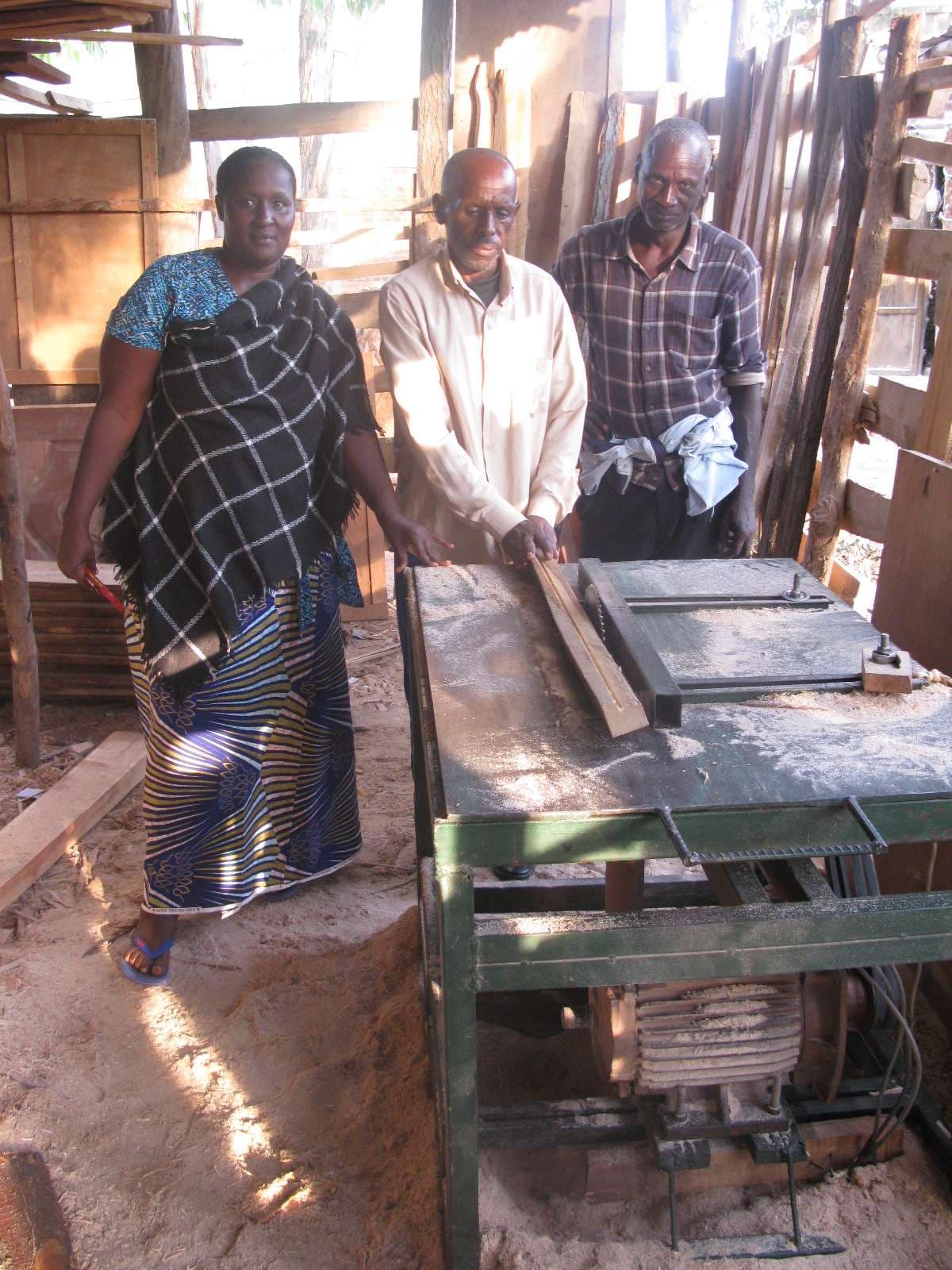 Members of the association demonstrate how the Wood trimming machine works.