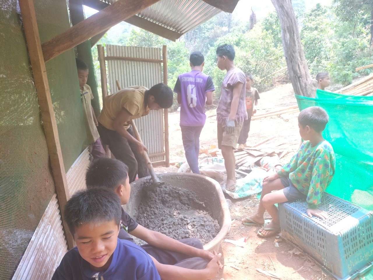 The children mix the cement to make pipes.