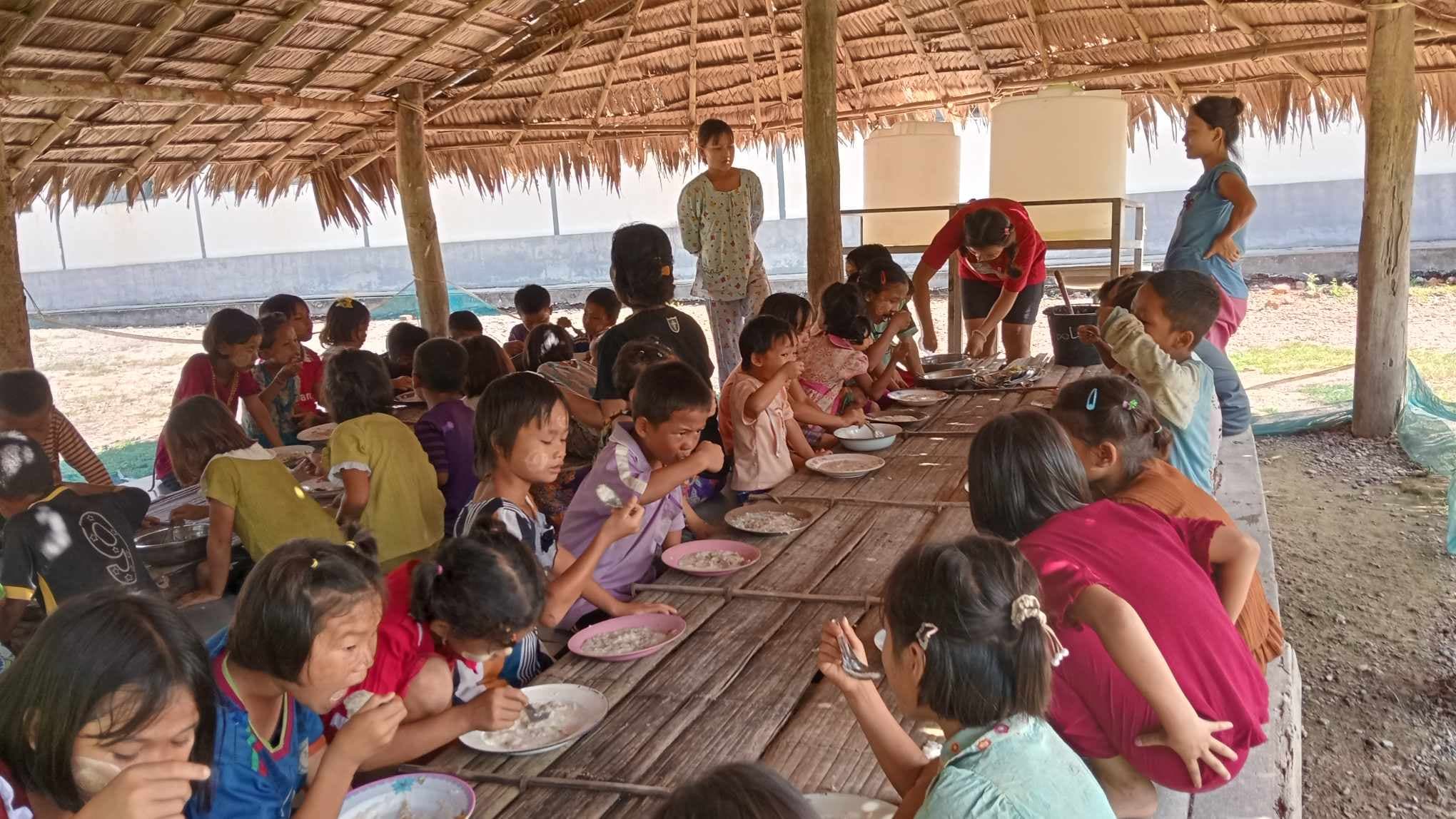 The children are enjoying their meals with great delight, savoring the delicious food provided for them.