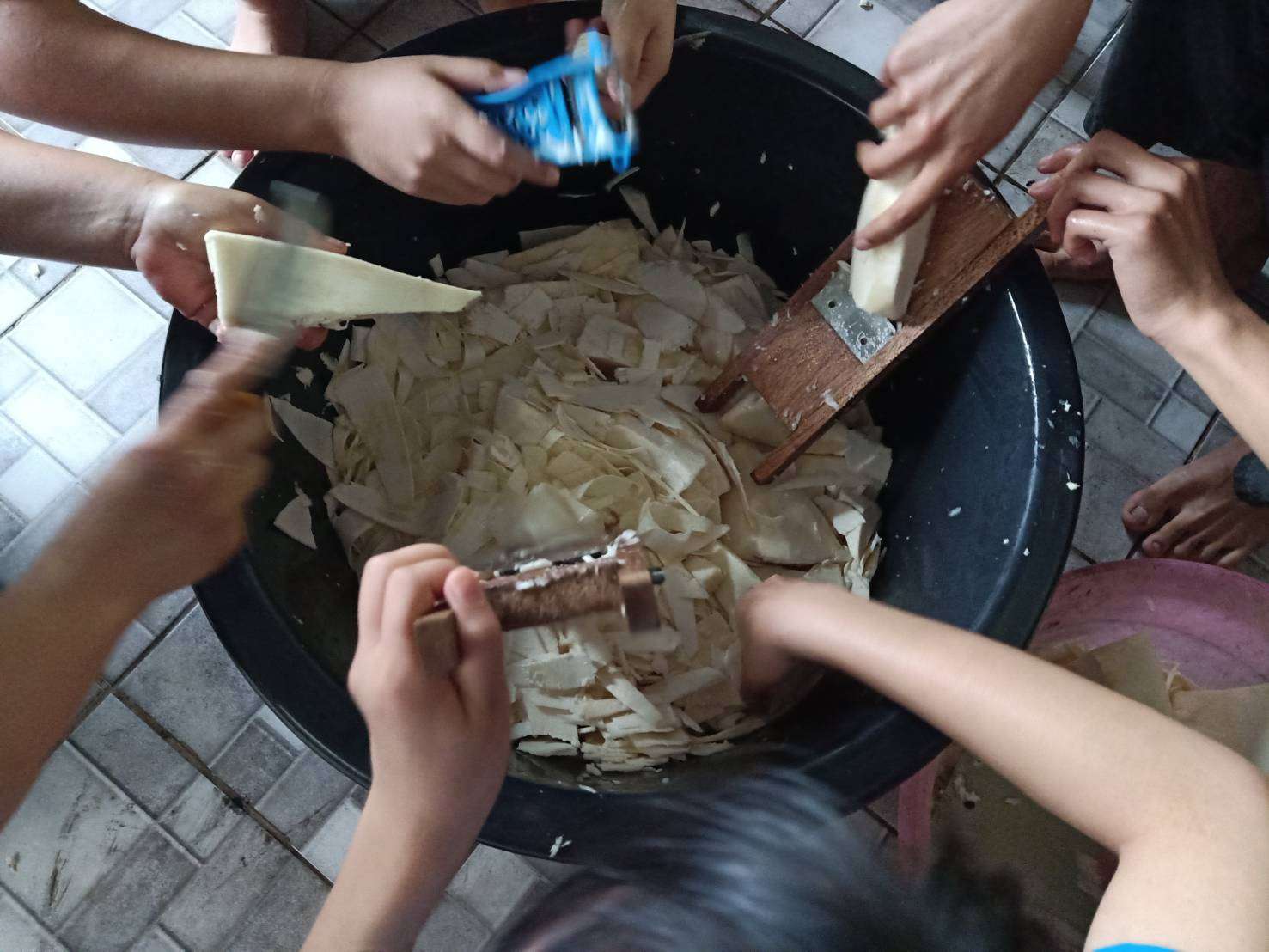 The children are thinly slicing bamboo shoots.
