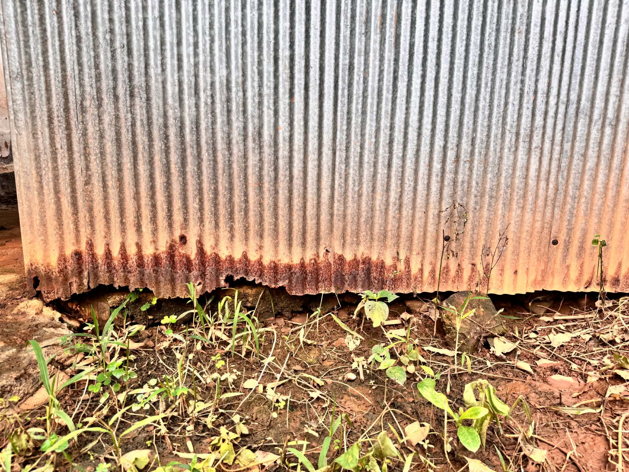 The restroom's zinc walls have deteriorated, compromising both safety and privacy.