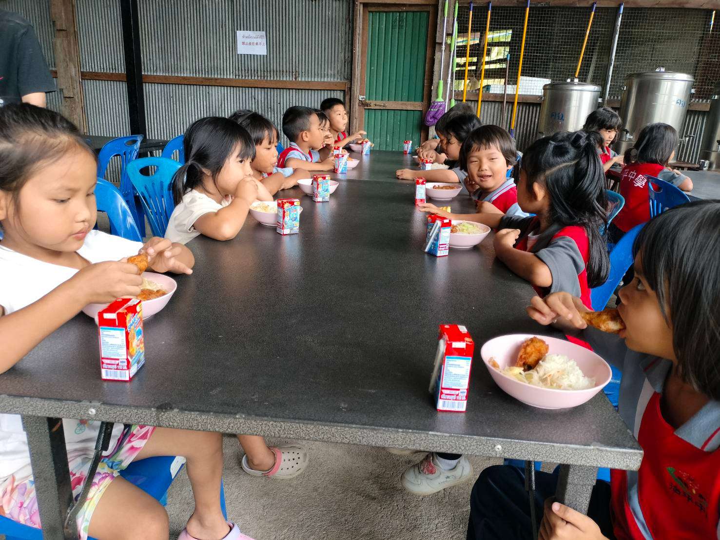 The children's lunch consisted of sticky rice with fried chicken and their favorite milk.