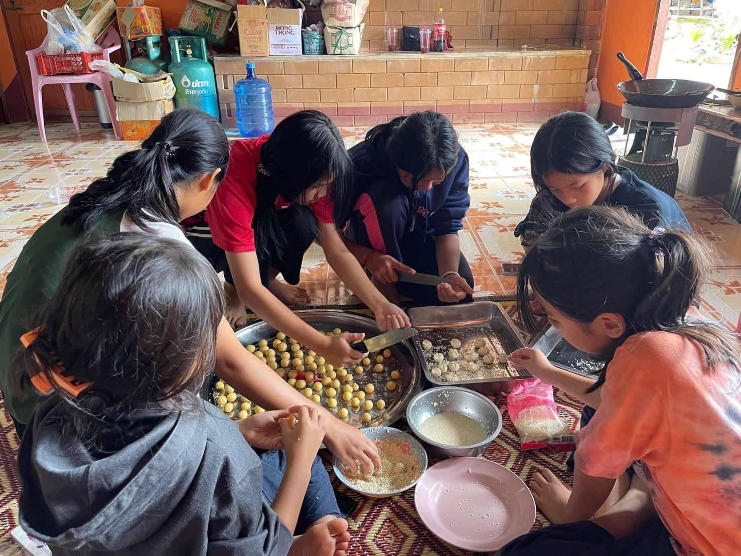 Children happily making the local cookies, showing their engaging participation in the baking process.