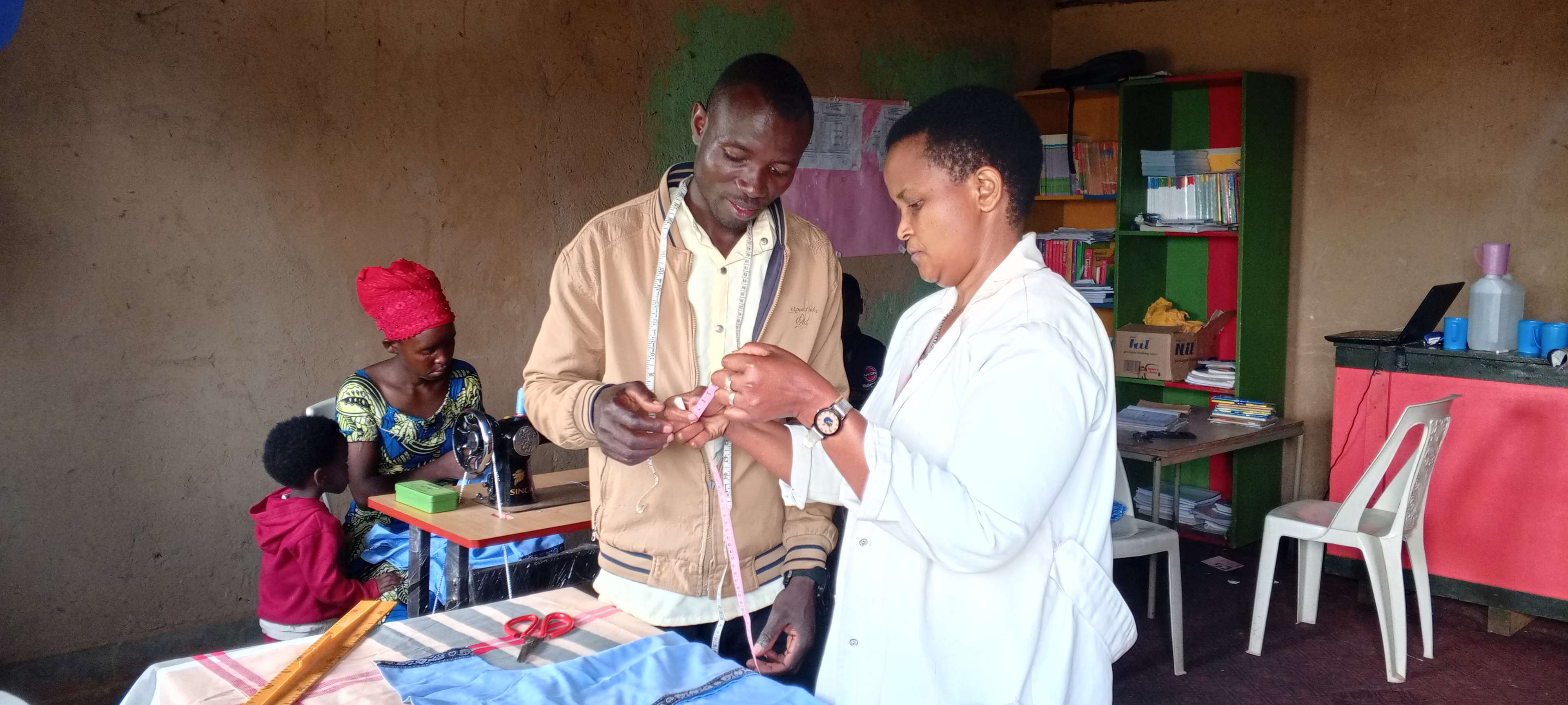 Caregivers are learning how to make use of a measuring tape for tailoring.