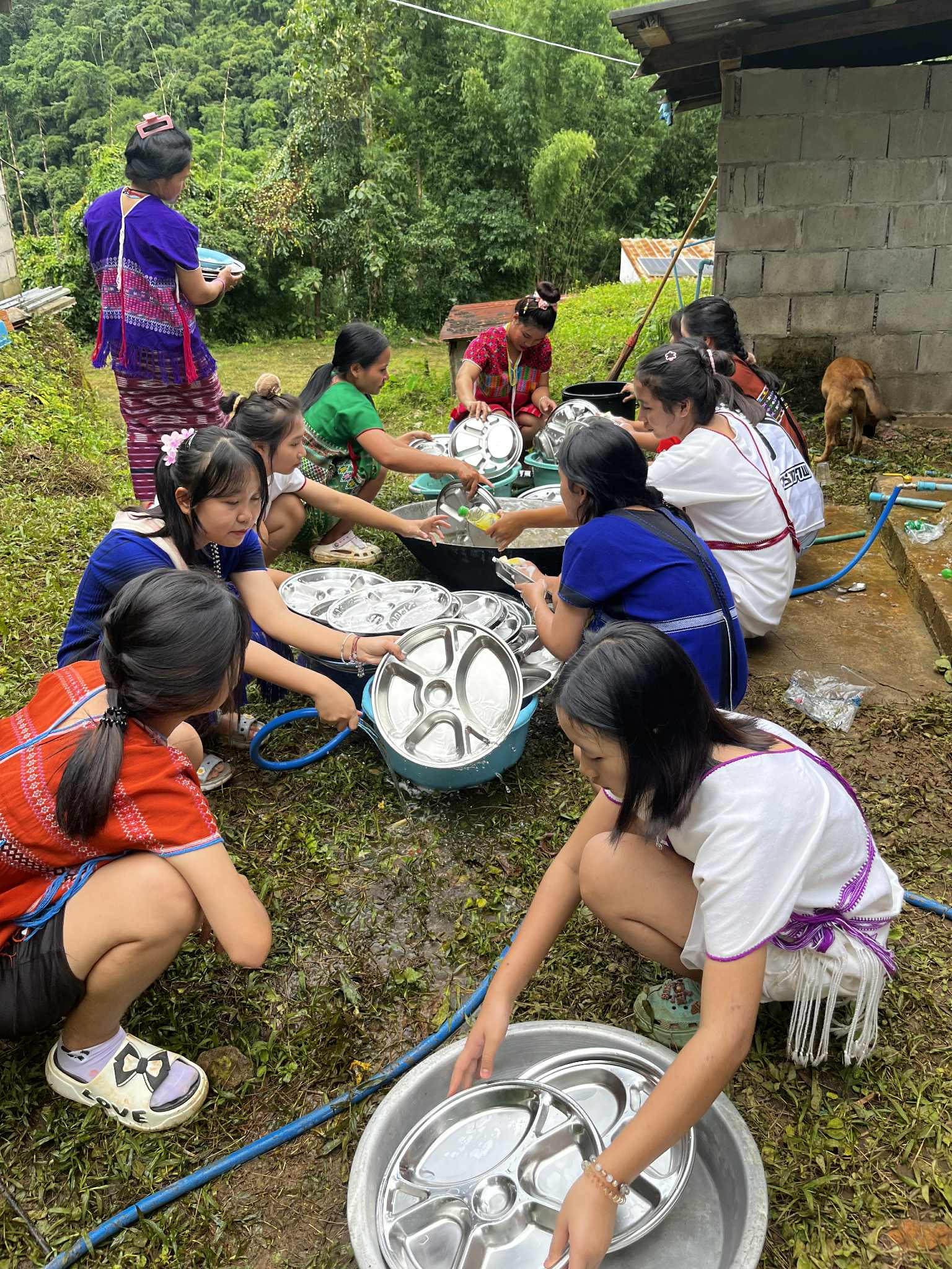 Youth are washing dishes from Water Tank 