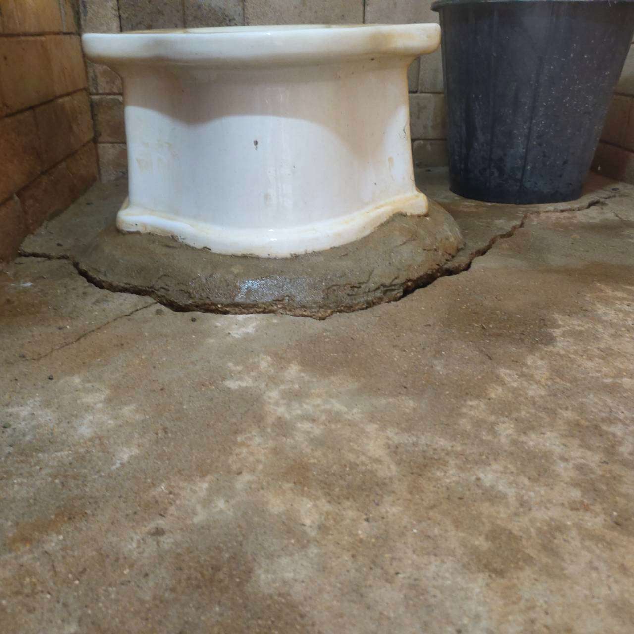 The bathroom has developed stains and cracks due to prolonged use.