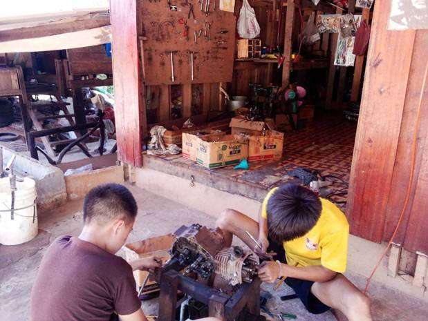 The youths are assembling motorcycle parts.