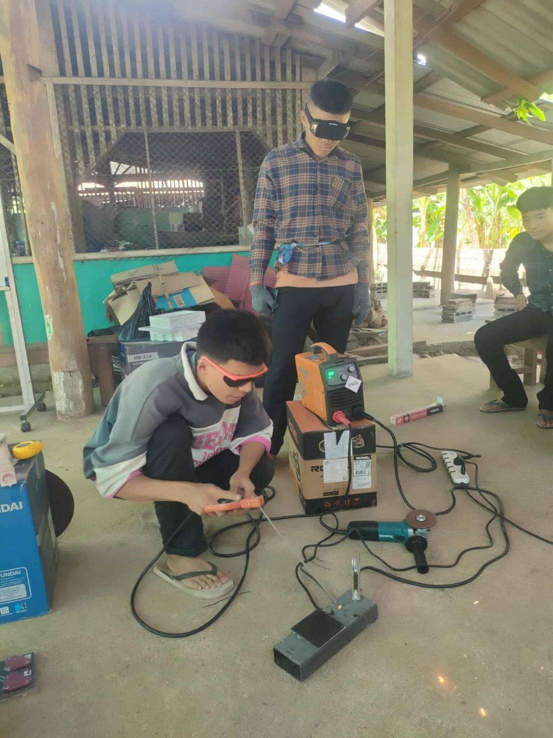 Trainer demonstrating welding techniques to enhance practical skills
