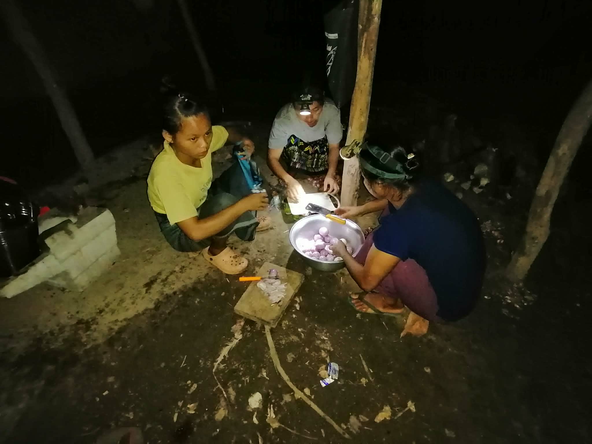Families cook at night in homes without electricity or proper lighting.
