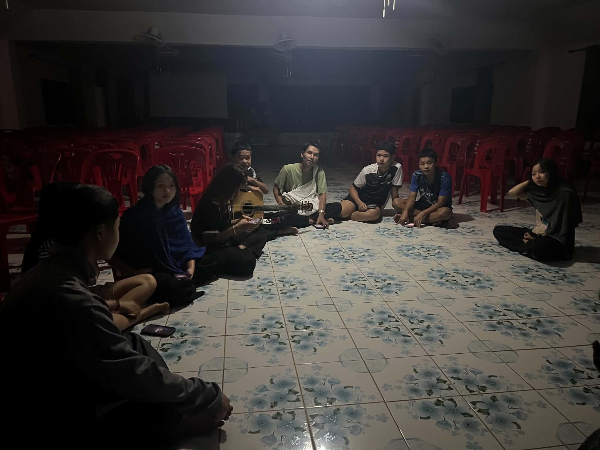 The youth group rehearsed worship songs in the evening for Sunday Services, which were held in a room with insufficient lighting.