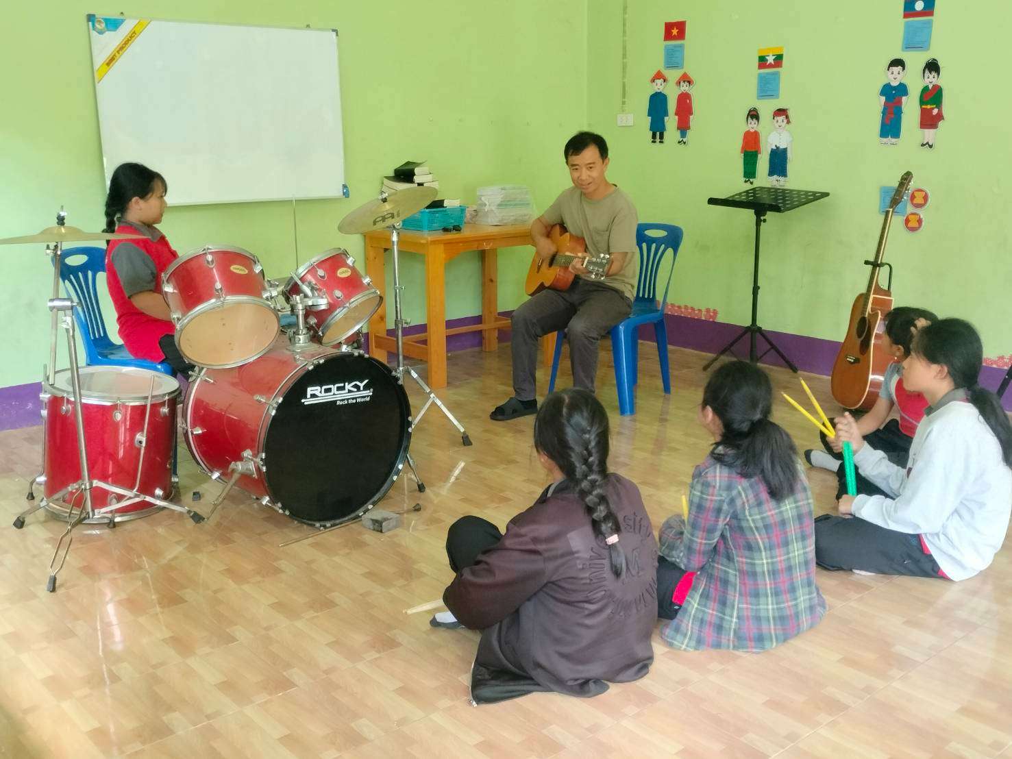 The youths are divided into age groups for their drumming lessons, lining up in order.