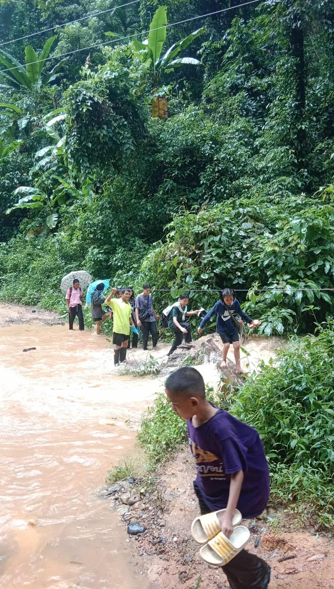 Ready for adventure: A group of young children anxiously waiting to cross the stream on their way to school in the morning