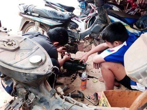The young people are practicing disassembling motorcycle parts.