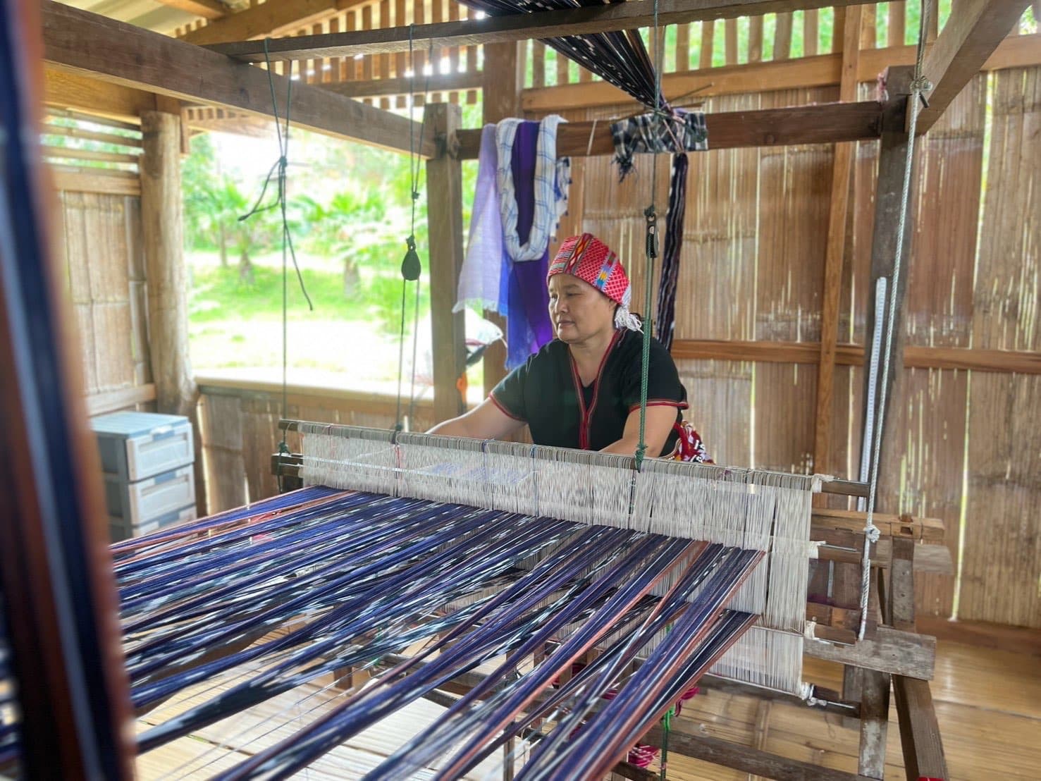 Weaving fabric using a traditional foot-treadle loom.