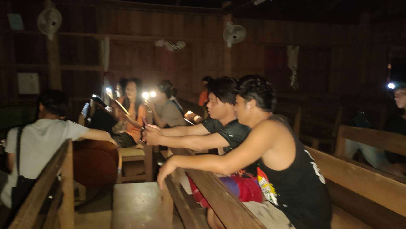 The children practiced the song in the church meeting room, using flashlights because there was no electricity or lighting.