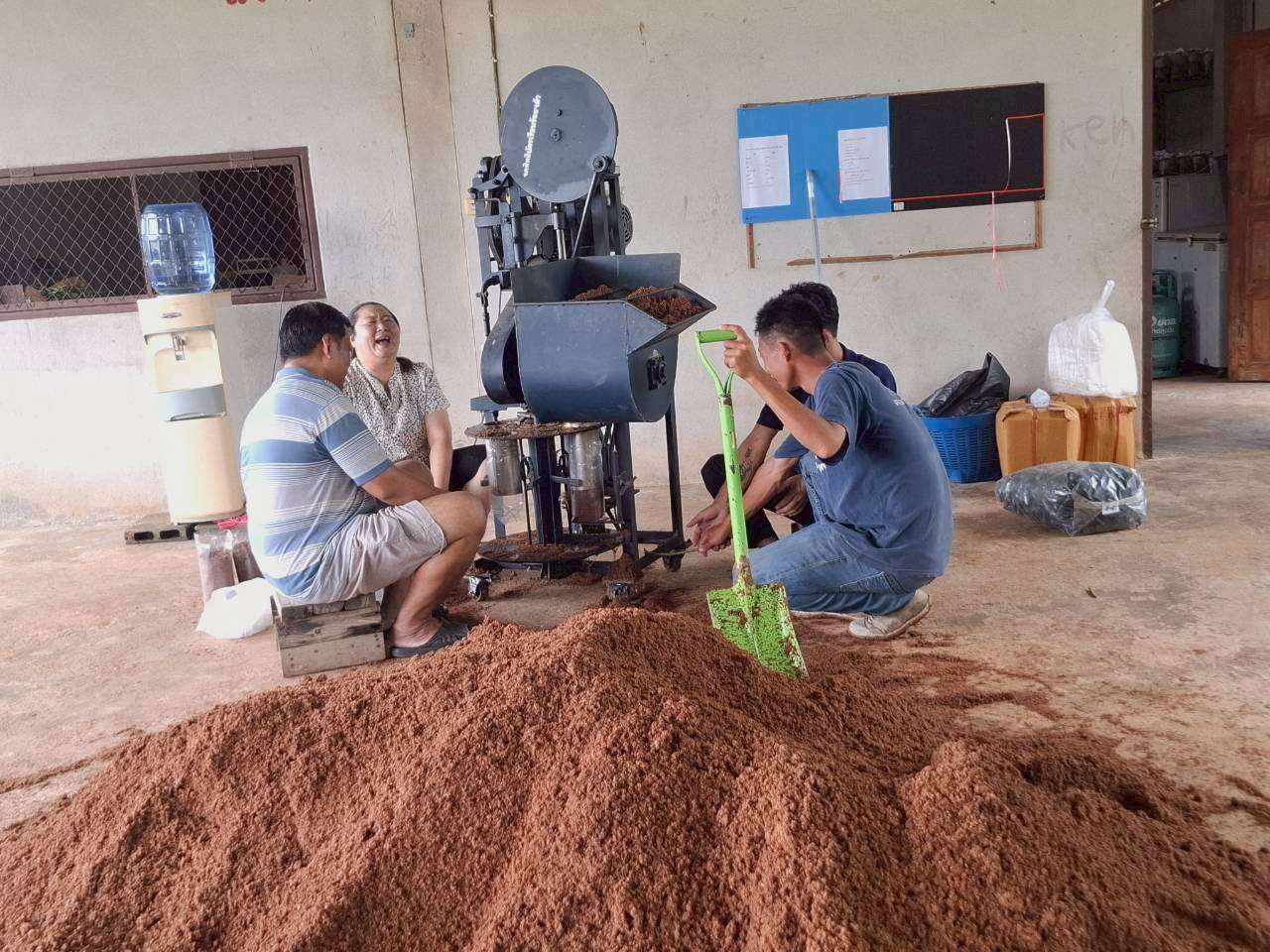 Adults are helping children use the mushroom block press machine.