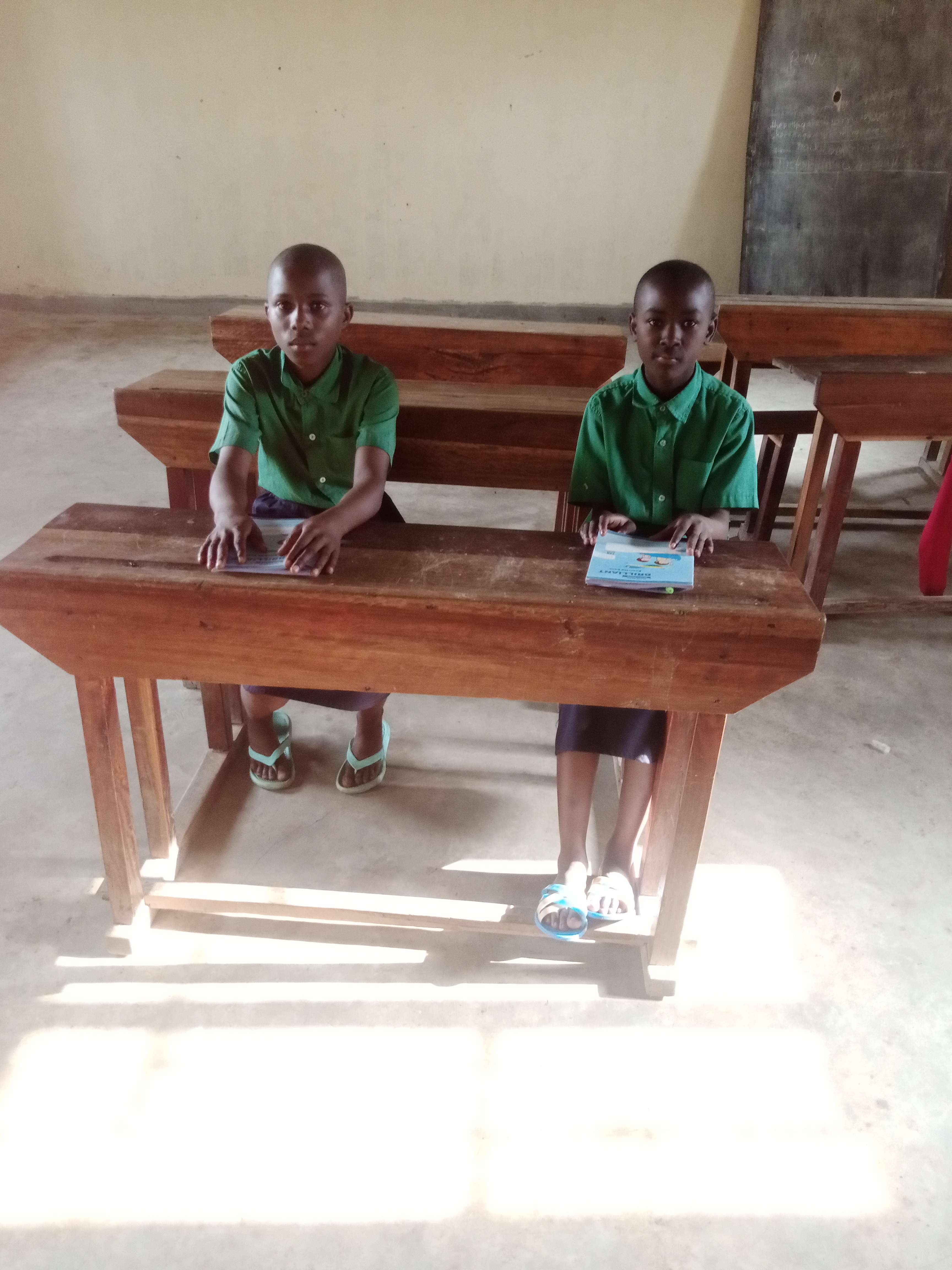 Girls are seated on the two out of 5 desks, available in one of the classes. Other classes have no desks.