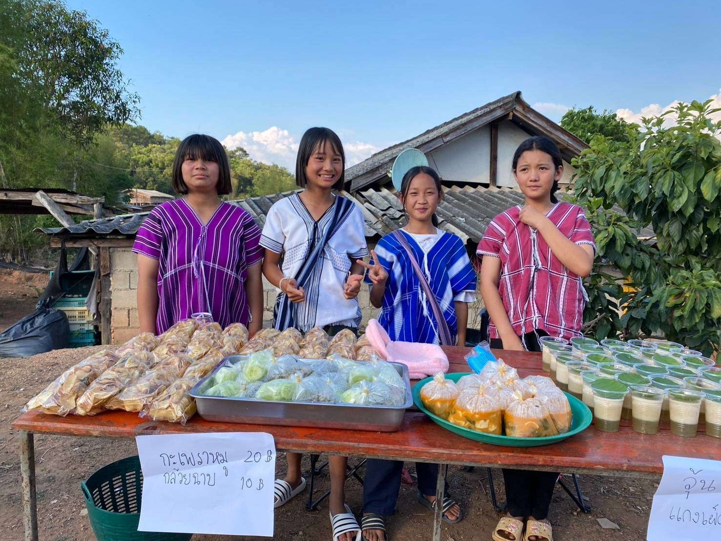 Young people prepare food and desserts to sell at the village children's market.