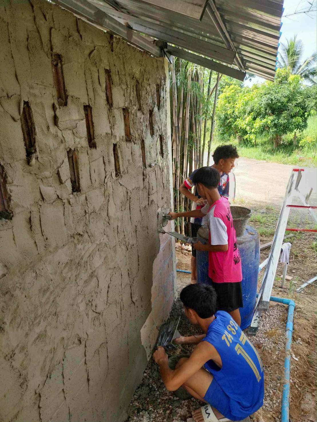 Youth learning the craft of plastering in hands-on training.