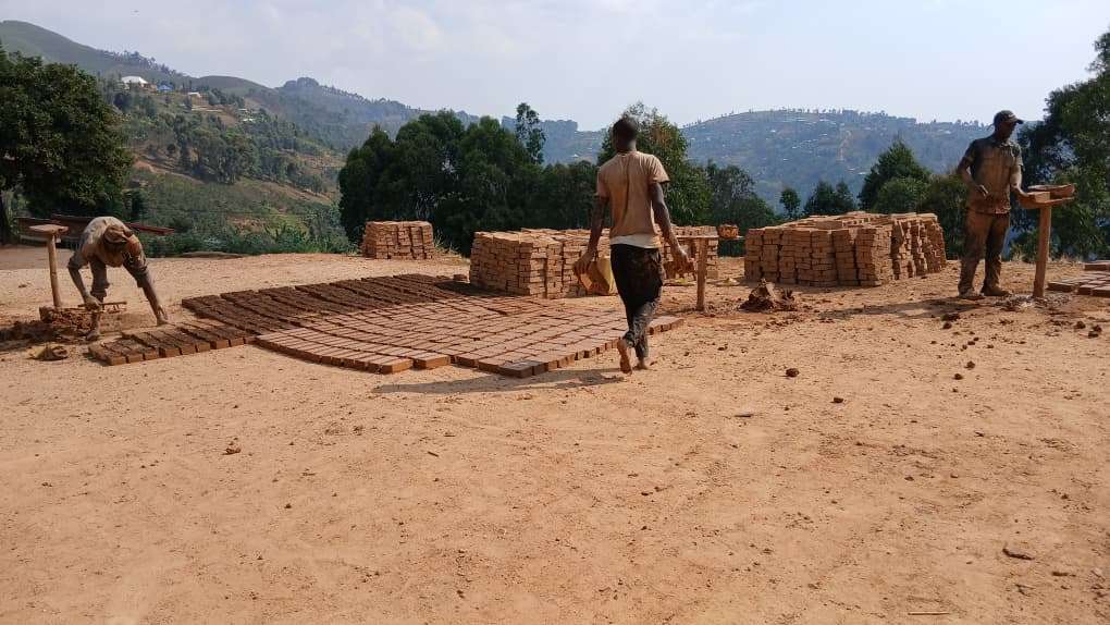 The caregivers are making bricks.