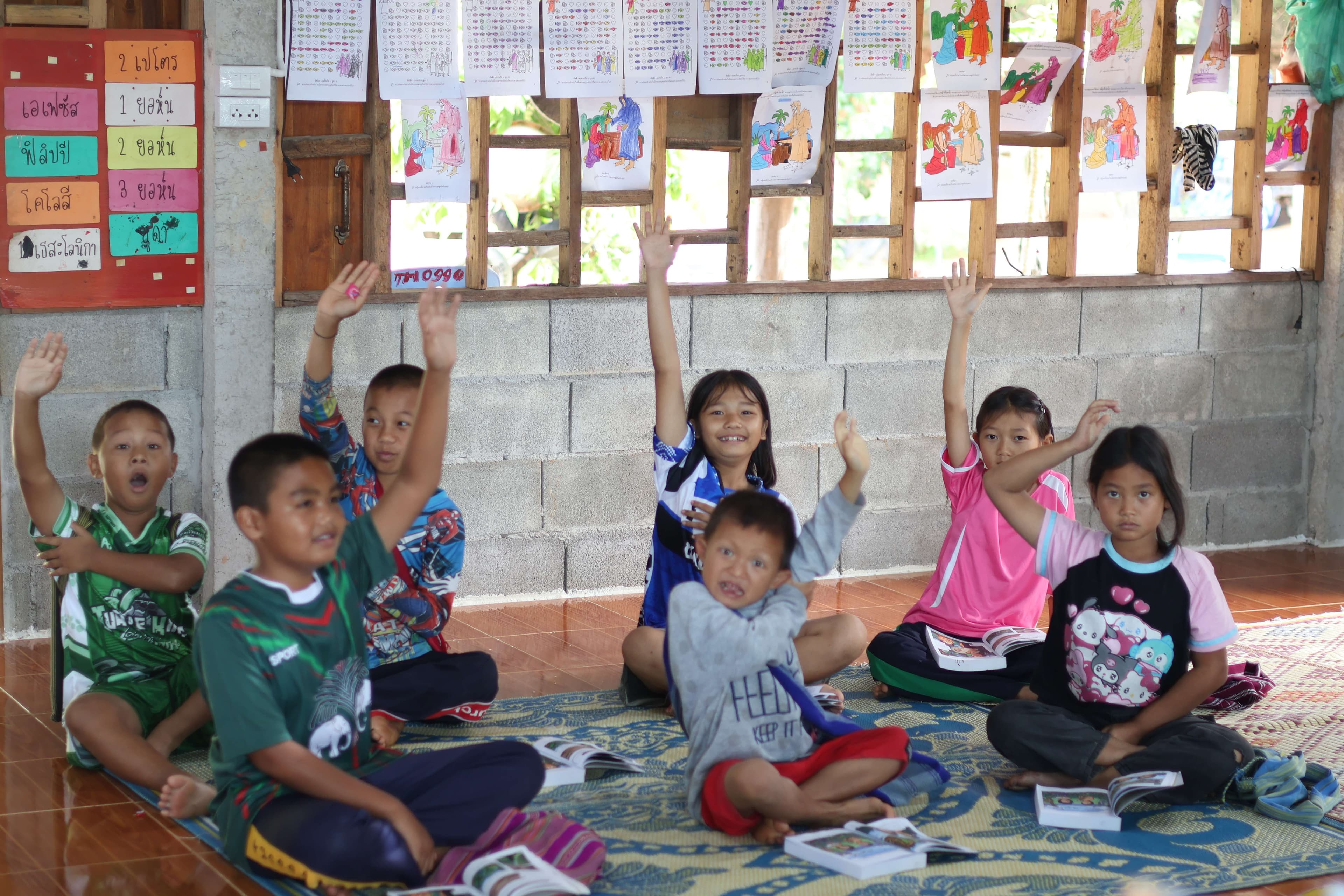 The children were sitting on the floor reading books, which caused them to sit crookedly.