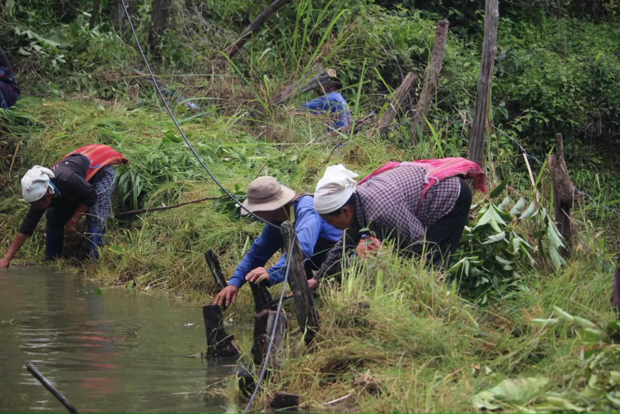 Community members working together to clean and maintain the water well, ensuring its safety and sustainability.
