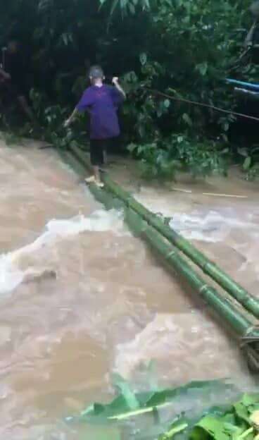 A bamboo temporary bridge in use, showcasing the community's resourcefulness in navigating the stream despite its challenges