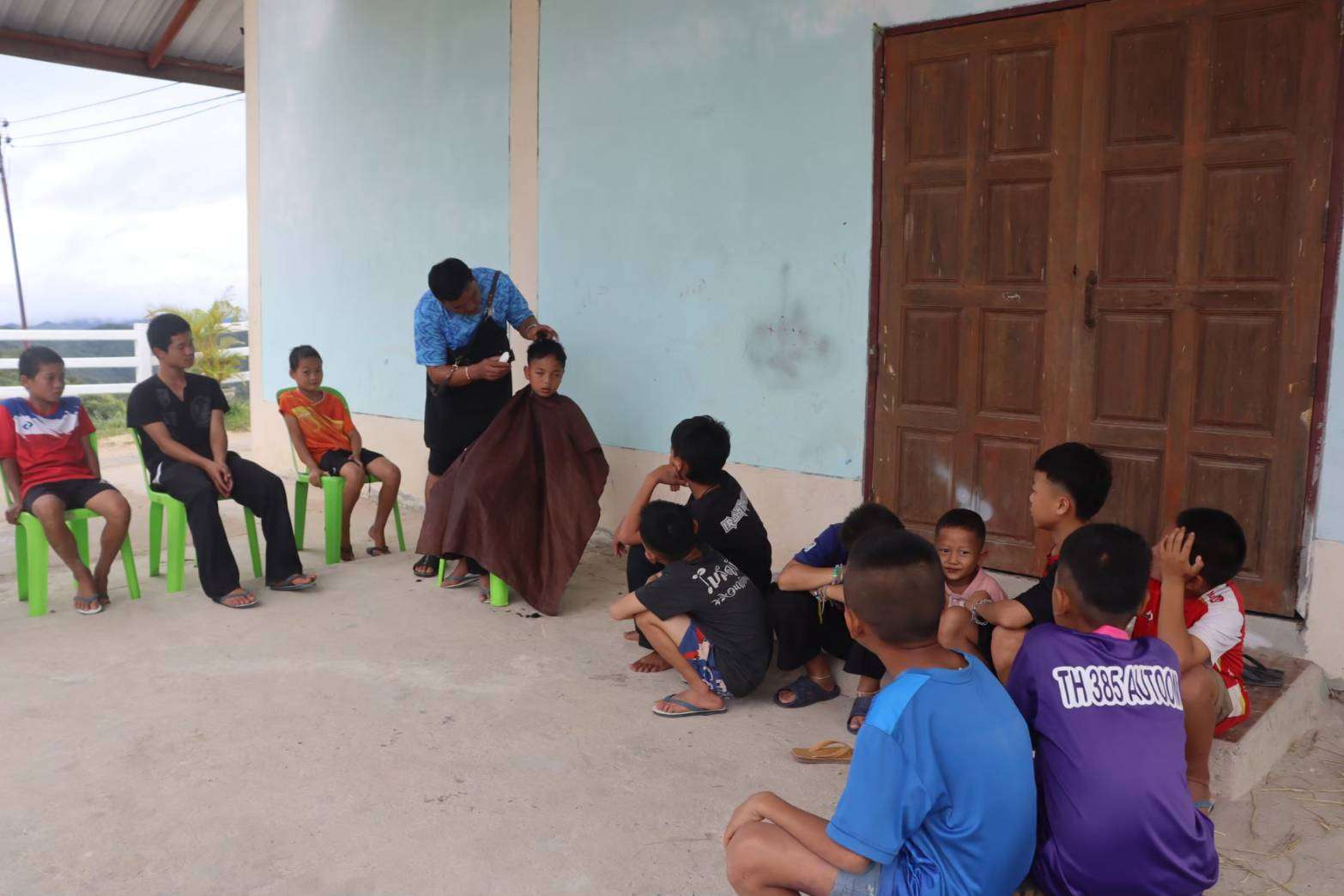 Children learning haircutting skills from the instructor.
