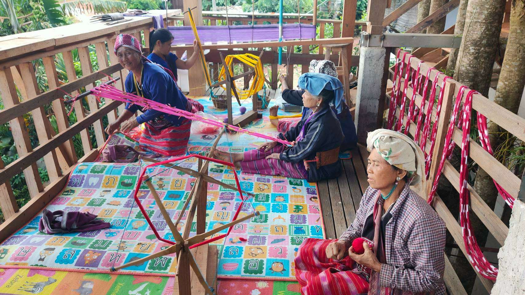 Elderly people gathered together to do weaving activities.