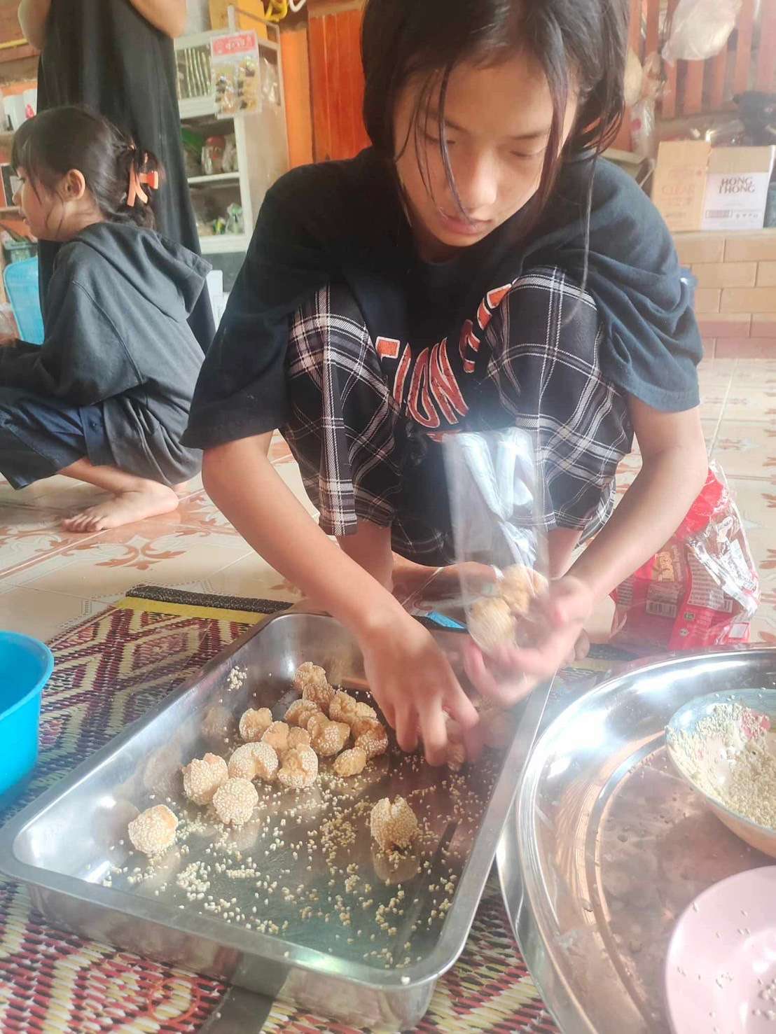 Children carefully packaging cookies into bags, demonstrating the practical steps of preparing products for sale.