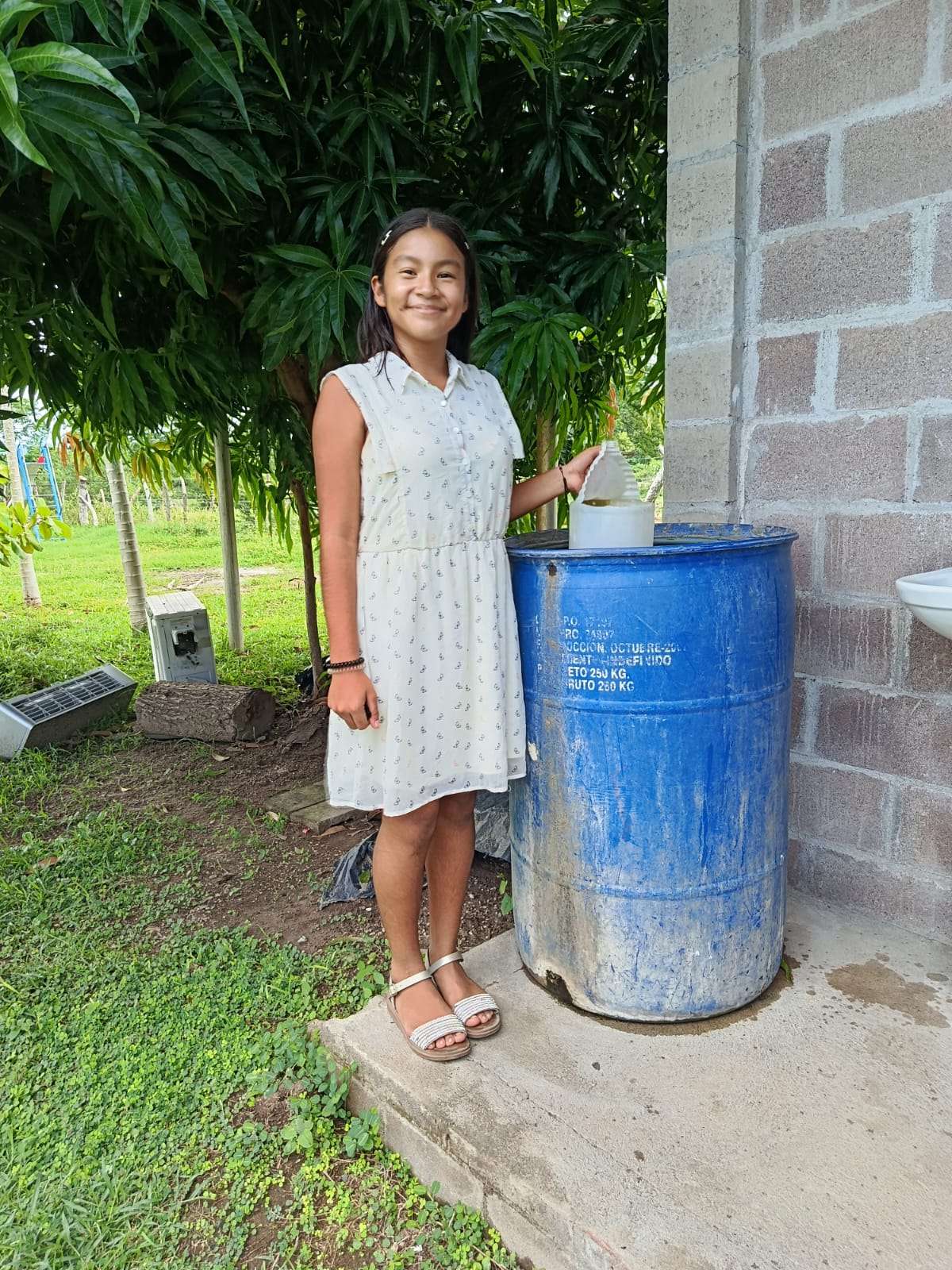 Young participant next to a water storage container