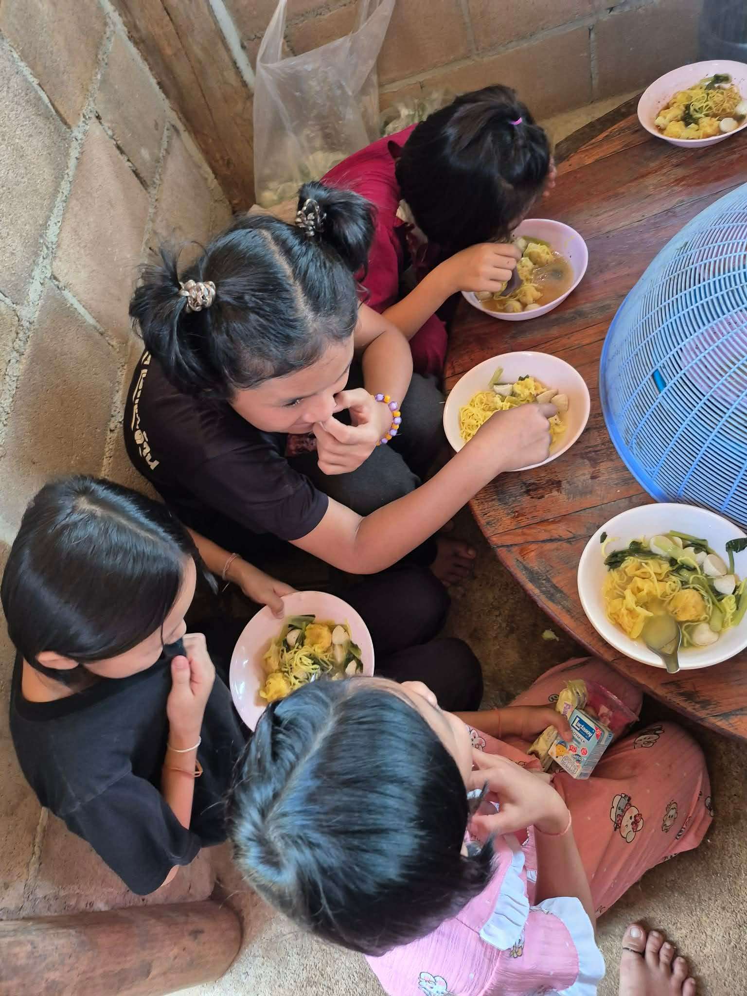 The children enjoy their meal with clean water to drink.