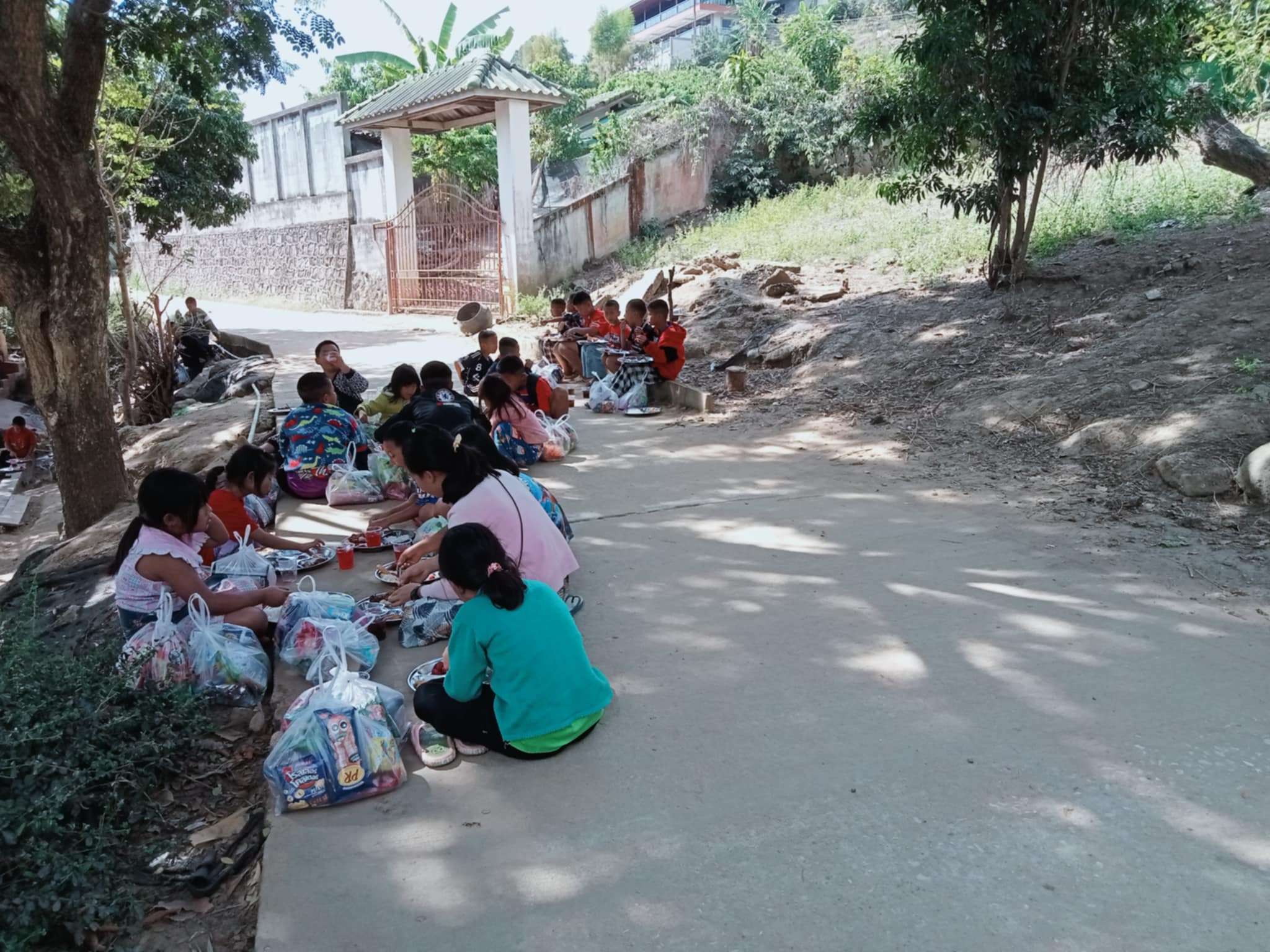 
"Finding joy in simple moments: Our children enjoy their meals under a tree on the street, reminding us of the importance of nurturing hope and community as we strive to build the Canteen of Hope."