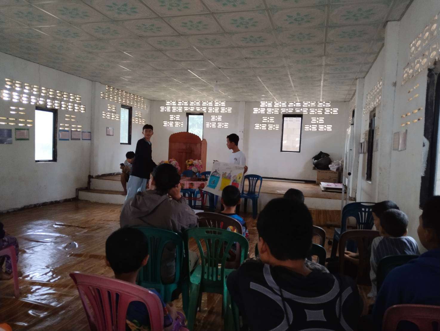 Older students teach the younger students proper waste separation techniques.