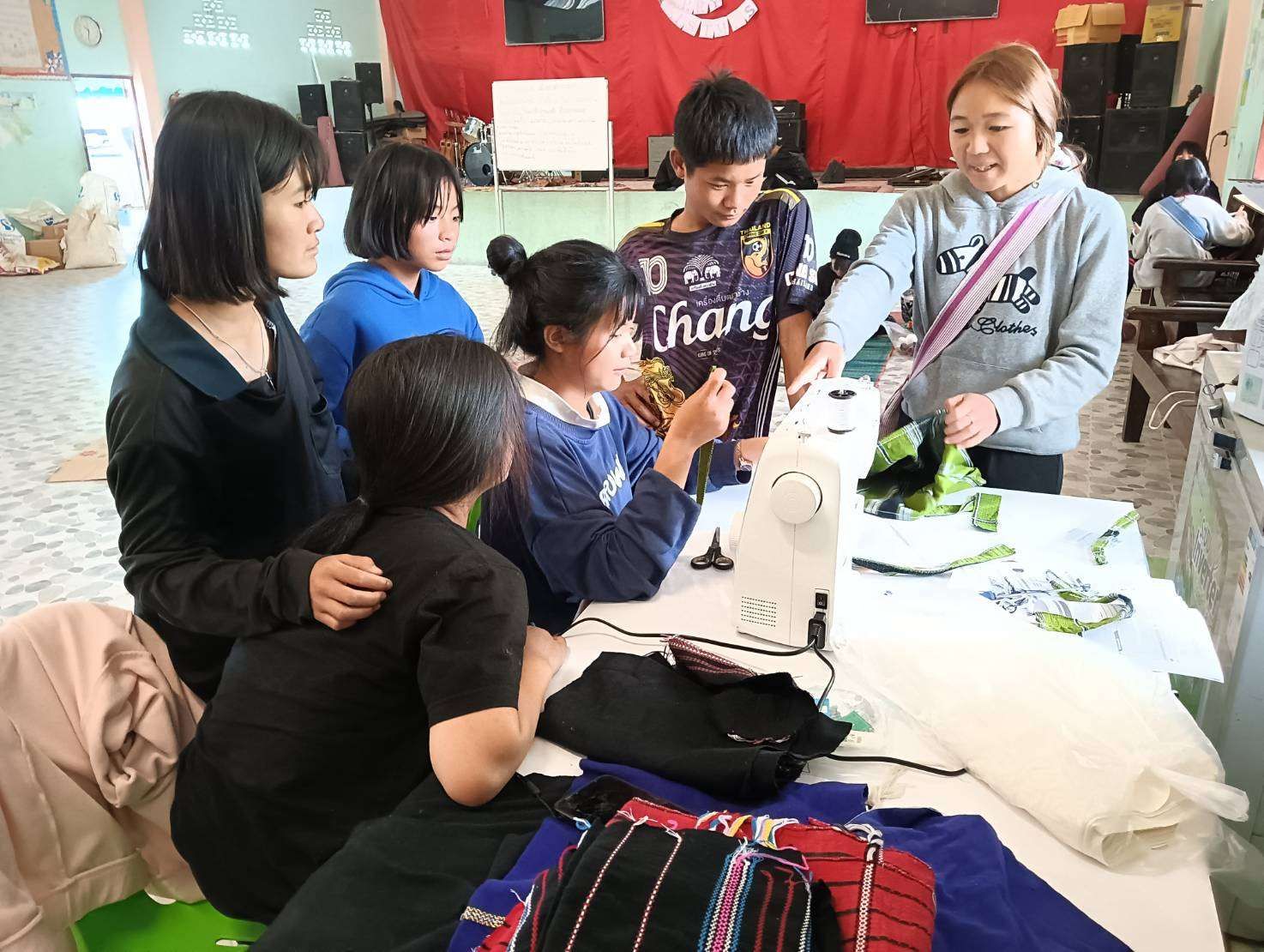 Children gaining confidence and skills as they learn to operate an electric sewing machine.