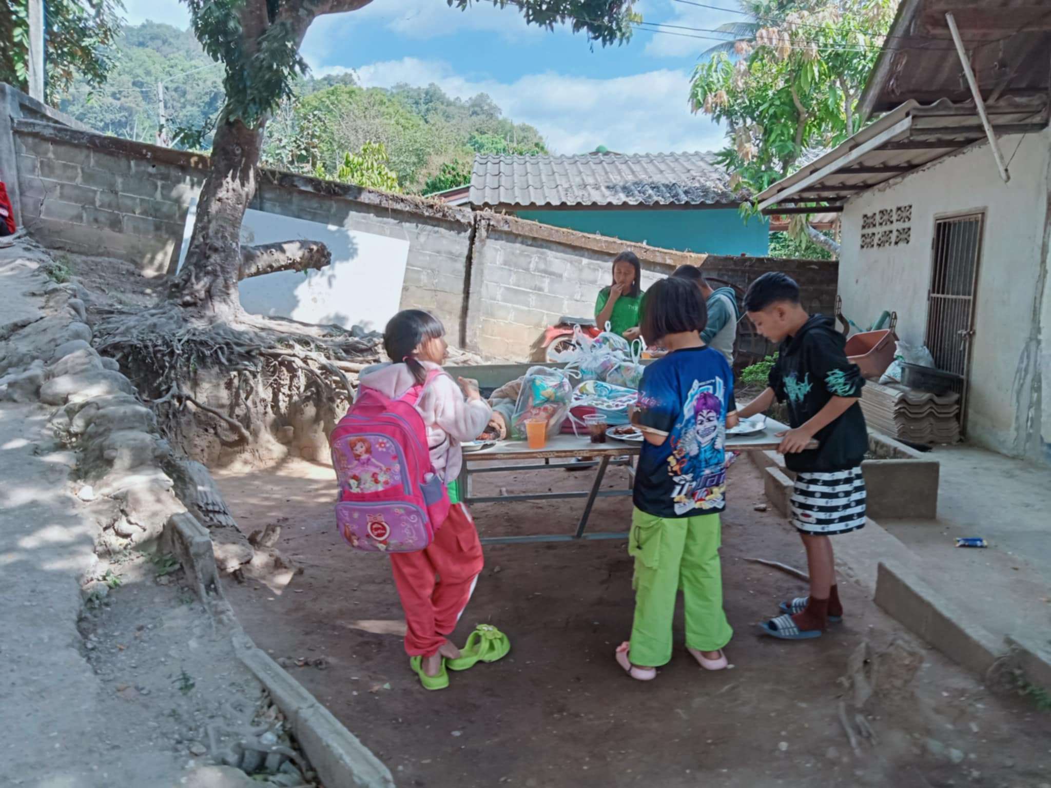 "Sharing meals and smiles: Our children gather around the ping pong table!
