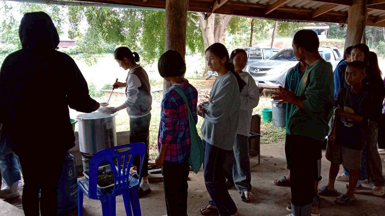 Children lining up excitedly to receive nourishing food.