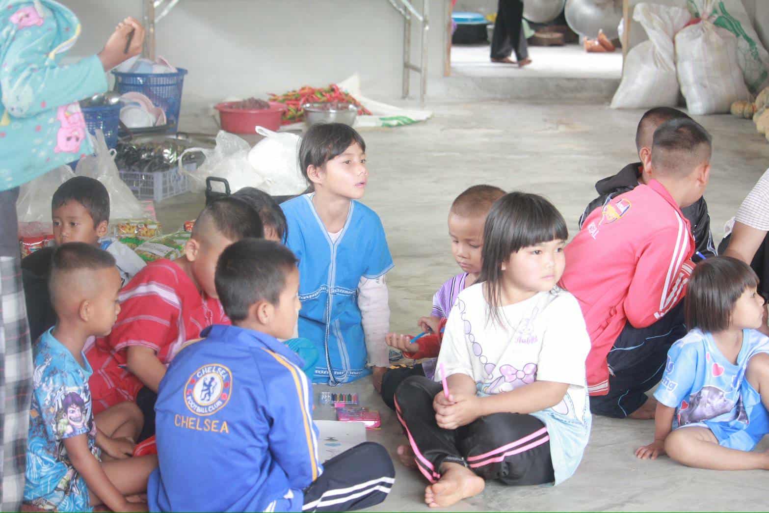 "Safety first! Our children patiently wait to cross the river, emphasizing the importance of protecting their lives during their journeys."