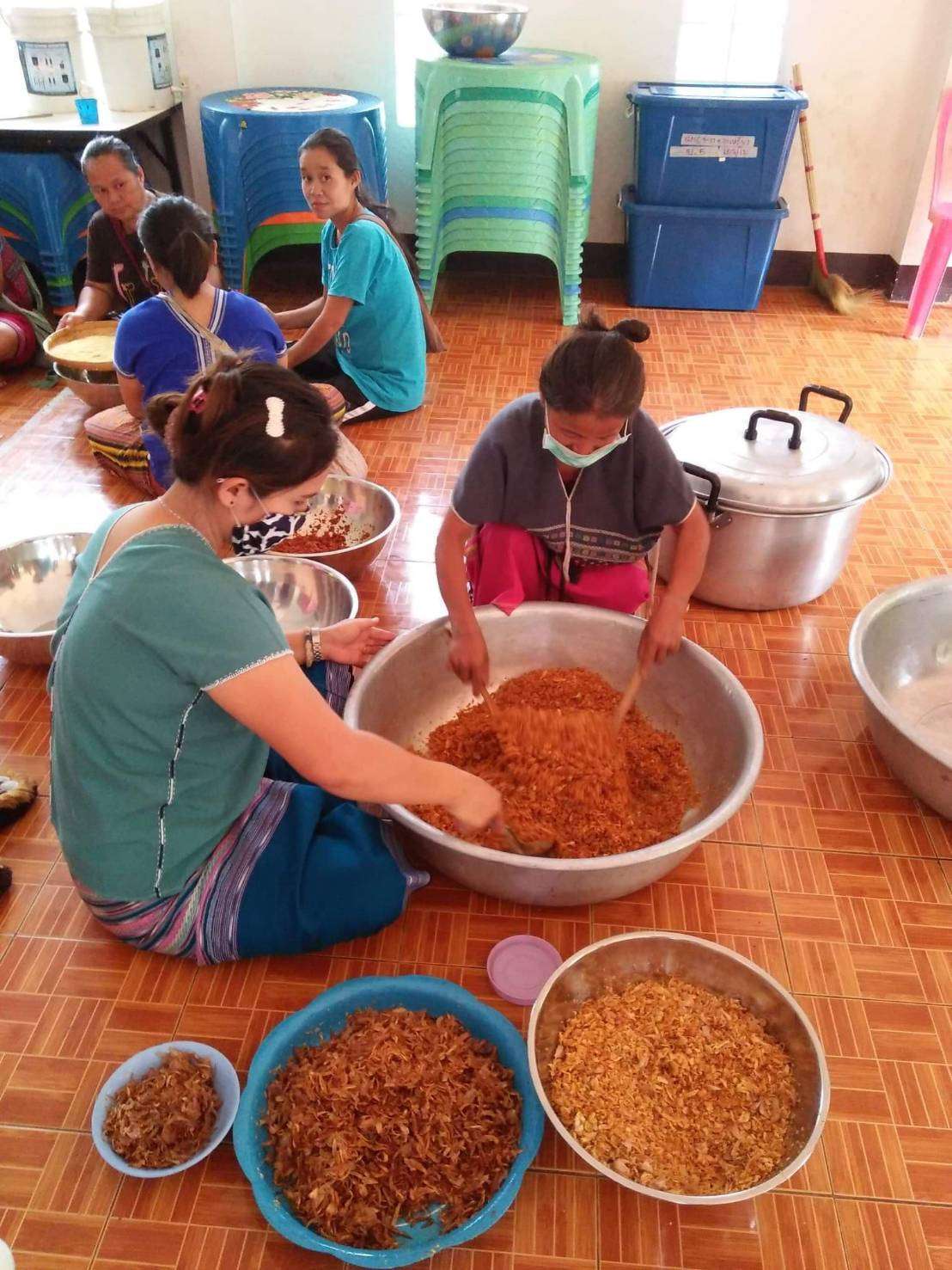 Youth and parents make galangal chili paste and salted fish.