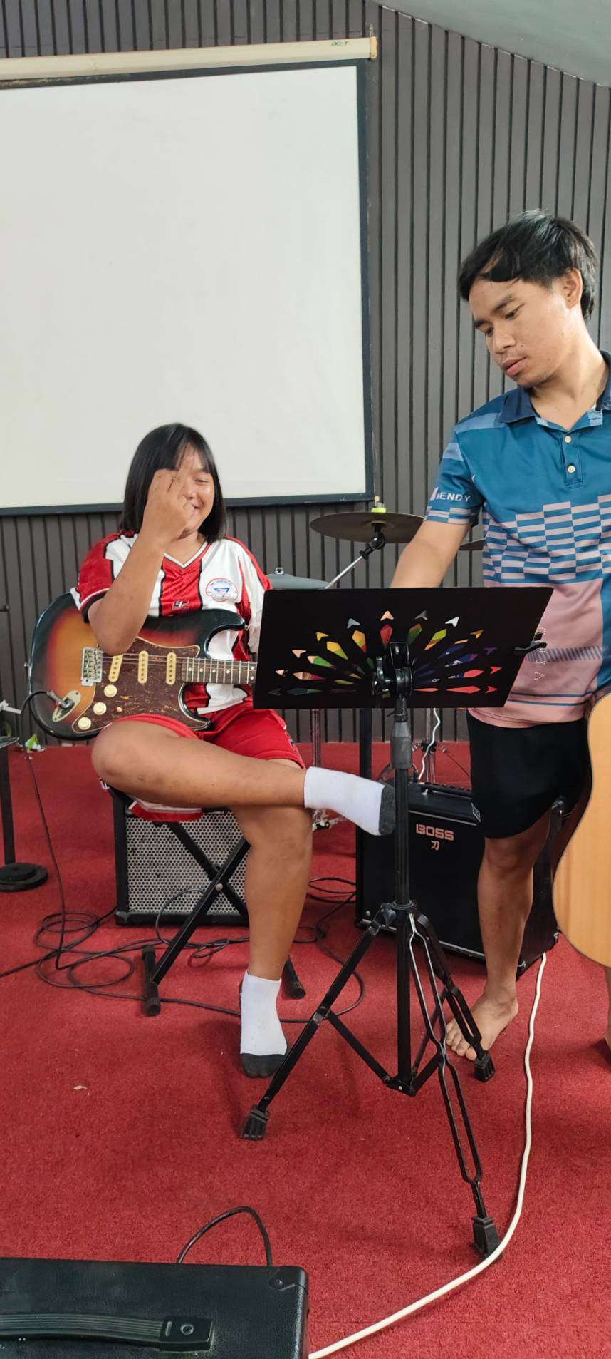 The child is learning to play the guitar.