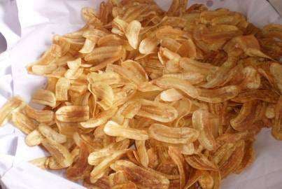 Banana chips are placed in a container before being packed in bags.