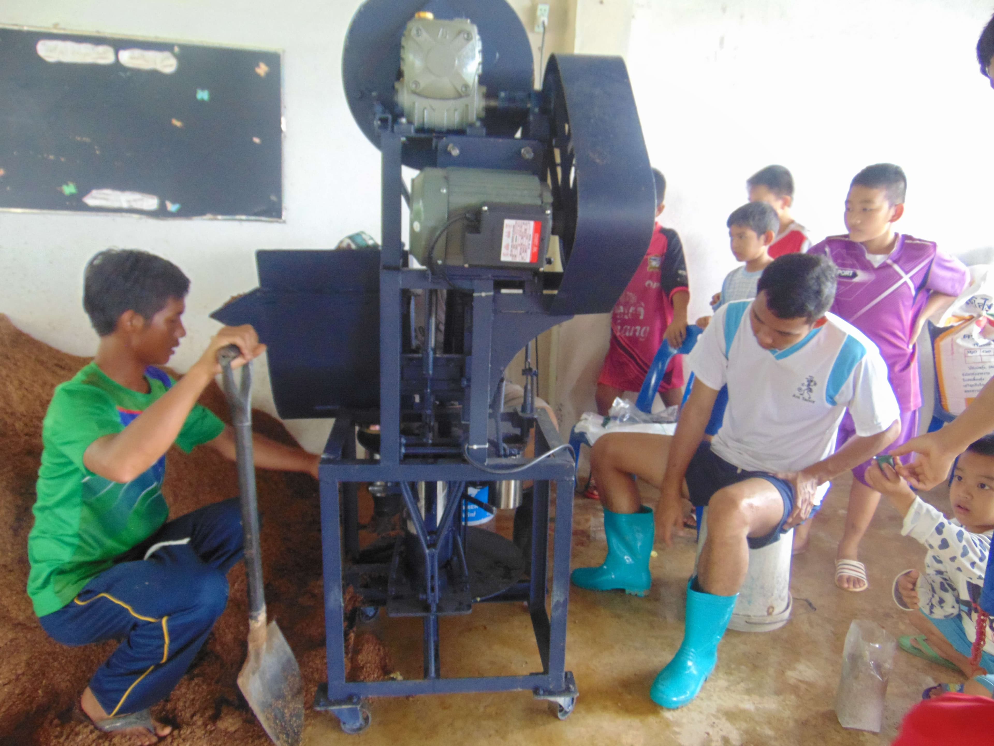 Explaining how to use a mushroom block press to the children.