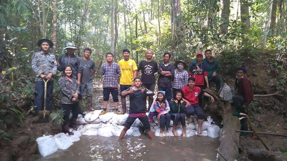 Children and parents work together to conserve water sources.