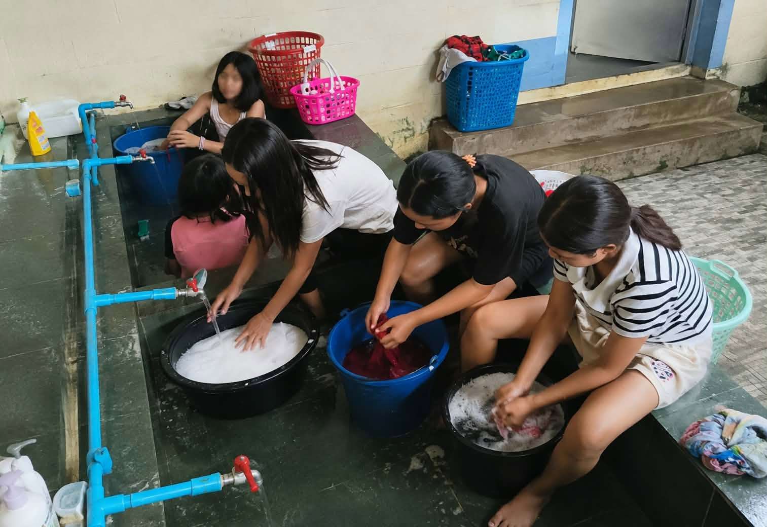 The girl is washing clothes by hand.