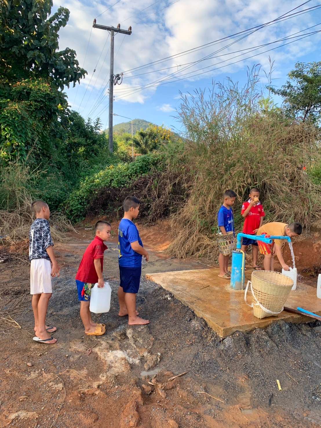 Children are lining up to scoop water.