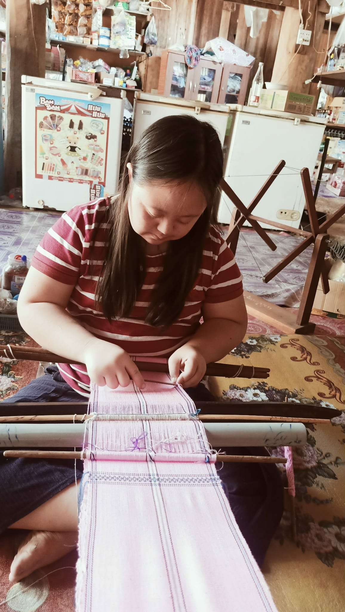 Project members weave bags, skillfully inserting wooden pegs to secure the fabric and bring their craftsmanship to life.