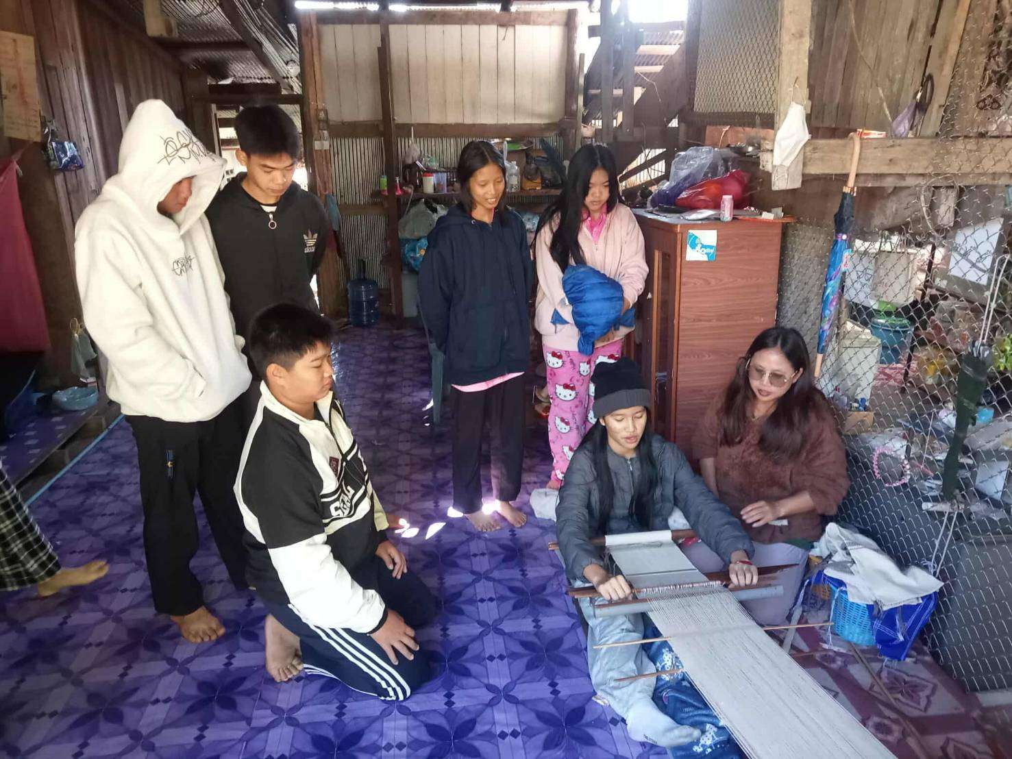 Learning the Craft: Youth and children eagerly engage with project staff as they learn the art of weaving, fostering a love for traditional skills and community togetherness.